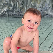 Diego Pieddefer participe au concours pour gagner de l'argent avec cette photo : toddler, child, pool, water, wet, smiling, blue_eyes, skin, hand, face, hair, rock_wall, tiles, crawling, wristband, playful, outdoor, cute, young, person