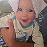 baby, infant, child, smiling, happy, portrait, pink_bow, headband, adult, parent, arms, cuddling, car, vehicle, indoor, dinosaur_clothing, onesie, close_up, family, joy