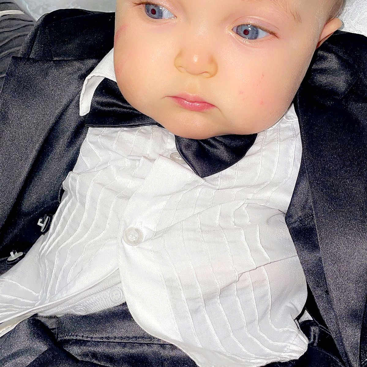 Ayoub a rejoint le concours — aidez-le/la à gagner de superbes lots ! baby, baby_boy, blue_eyes, bow_tie, child, closeup, clothing, cute, expression, face, fashion, formal_wear, indoor, infant, person, portrait, serious, suit, tuxedo, young_child