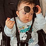 Ayoub a rejoint le concours — aidez-le/la à gagner de superbes lots ! toddler, child, stroller, sunglasses, sitting, casual_clothing, mickey_mouse, sweatshirt, jeans, baby, seatbelt, black_stroller, hand_gesture, indoor, cute, face, hair, expression, toy, white_background