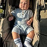 Brixton is registered to the contest to win money with this photo: baby, child, stroller, clothing, socks, face, person, outdoor, sunlight, shadow, seat, infant, cute, casual, portrait, young, babywear, relaxing, daylight, expression