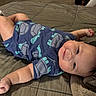 Brixton is registered to the contest to win money with this photo: baby, infant, child, onesie, blue_clothing, turtle_print, bed, blanket, lying_down, smile, face, chubby_arms, soft_lighting, indoors, cozy, cute, portrait, skin, head, happy