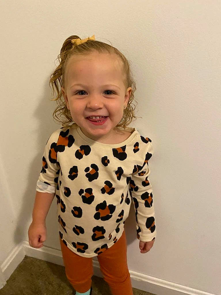 Diana is registered to the contest to win money with this photo: arm, baby, baby_toddler_clothing, cheek, clothing, eye, face, flooring, hair, happy, head, joy, knee, one_piece_garment, pattern, person, skin, sleeve, smile, t_shirt