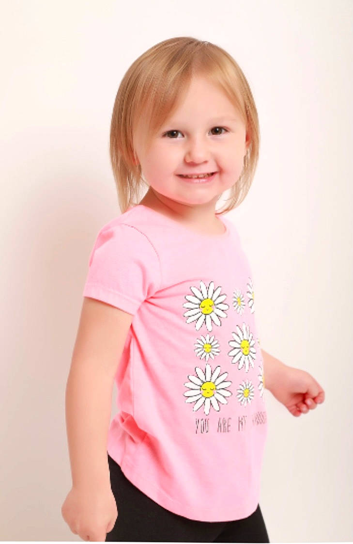 Lexie is registered to the contest to win money with this photo: arm, baby_toddler_clothing, cheek, eyelash, face, gesture, hair, happy, head, human_body, joint, joy, neck, person, pink, plant, product, shoulder, sleeve, smile