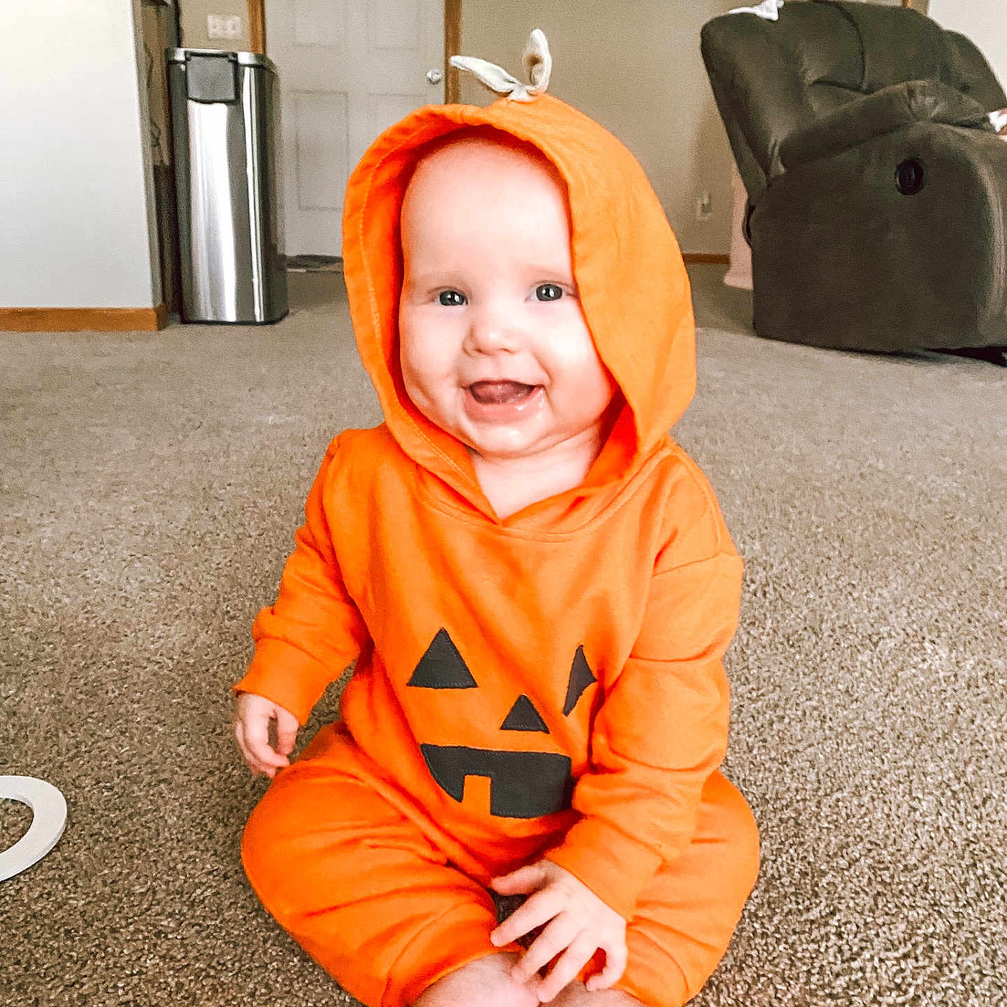 Brae joined the competition — help win amazing prizes! baby, carpet, casual, child, cozy, cute, face, feet, furniture, happy, home, hood, indoors, infant, living_room, orange_hoodie, playful, pumpkin_costume, sitting, smiling