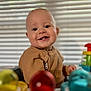 baby, background, blurred, child, clothing, colorful, cute, face, happy, high_chair, indoor, infant, person, portrait, ribbed, smiling, teeth, toy, window_blinds, young