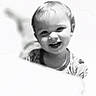 baby, background_blur, black_and_white, child, closeup, clothing, cute, expression, face, happy, head, indoors, monochrome, person, portrait, short_hair, smiling, soft_light, toddler, young_child