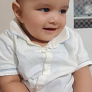 Abuzer joined the competition — help win amazing prizes! baby, child, smiling, indoor, white_shirt, striped_pants, biscuit, hands, face, cute, happy, sitting, young_child, portrait, infant, skin, head, eyes, mouth, furniture