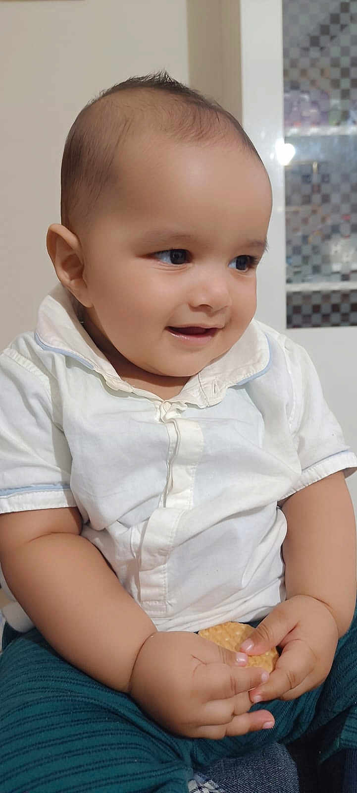 Abuzer joined the competition — help win amazing prizes! baby, child, smiling, indoor, white_shirt, striped_pants, biscuit, hands, face, cute, happy, sitting, young_child, portrait, infant, skin, head, eyes, mouth, furniture