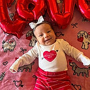 Harper joined the competition — help win amazing prizes! baby, infant, newborn, smiling, heart, valentine, balloon, red_balloon, pink_blanket, dog_print, bow_headband, onesie, striped_pants, lying_down, portrait, cute, happy, celebration, soft_texture, home_interior