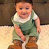 baby, brown_boots, child, cozy, cute, face, fluffy_blanket, footwear, green_overalls, hair, happy, indoor, infant, one_person, portrait, sitting, skin, smiling, white_shirt, young_child