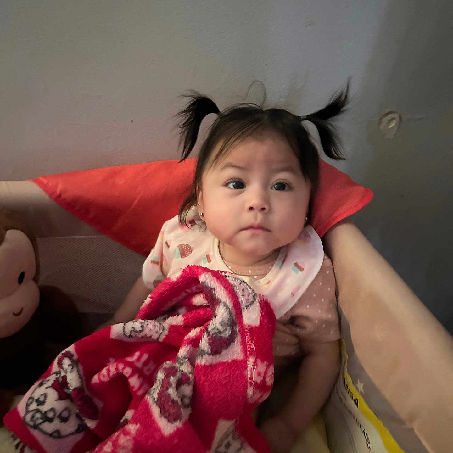 Zaira joined the competition — help win amazing prizes! baby, child, toddler, pigtails, portrait, sitting, blanket, red_blanket, bed, pillow, plush_toy, indoors, home, cozy, clothing, face, eyes, serious_expression, caregiver, photography