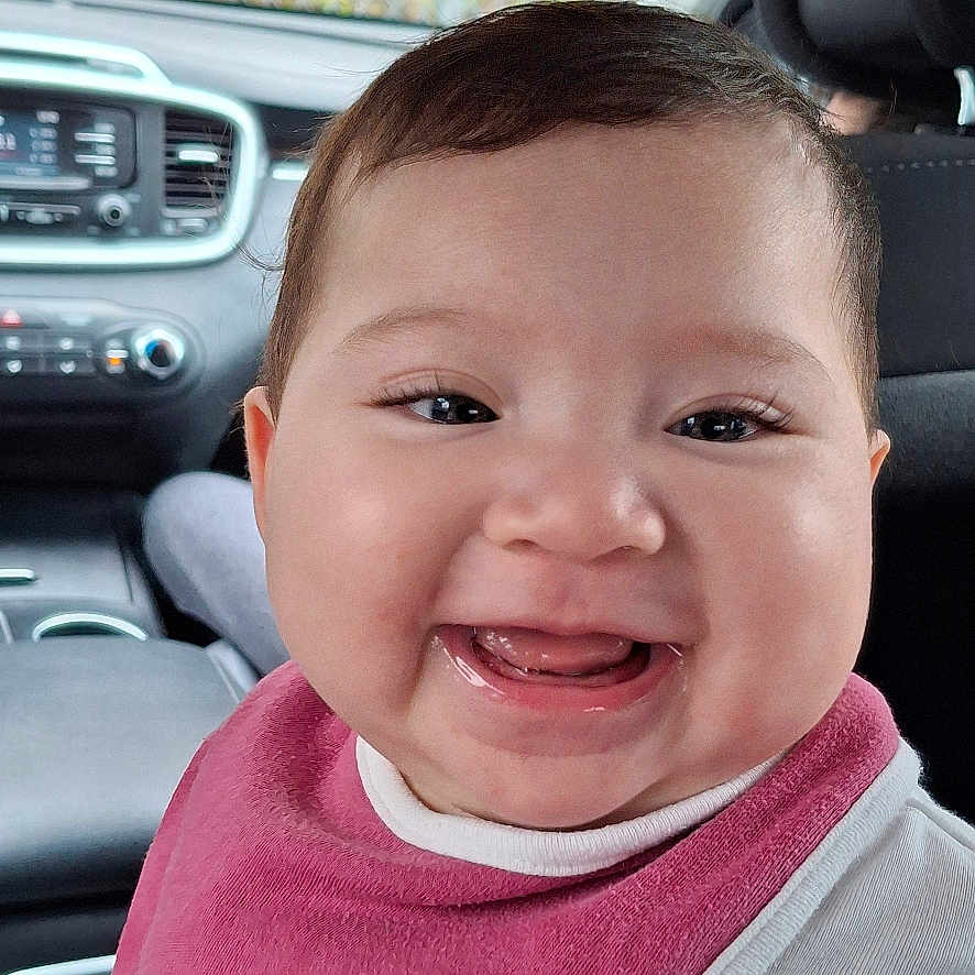 Briella joined the competition — help win amazing prizes! alloywheel, baby, bodypart, car, cushion, face, happy, head, headrest, homedecor, laughing, mouth, person, photography, portrait, sedan, smile, teeth, transportation, vehicle