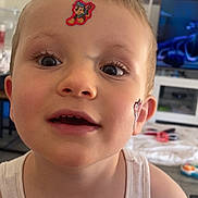 Scott a rejoint le concours — aidez-le/la à gagner de superbes lots ! child, toddler, face, sticker, cartoon, closeup, eyes, expression, tank_top, indoors, living_room, furniture, television, blurred_background, skin, hair, mouth, nose, ear, playful
