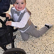Philippe a rejoint le concours — aidez-le/la à gagner de superbes lots ! child, toddler, boy, smiling, suit, bow_tie, white_shirt, grey_pants, stroller, kneeling, floor, indoor, happy, cute, fashion, baby_shoes, black_shoes, portrait, face, hands