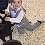 child, toddler, boy, smiling, suit, bow_tie, white_shirt, grey_pants, stroller, kneeling, floor, indoor, happy, cute, fashion, baby_shoes, black_shoes, portrait, face, hands