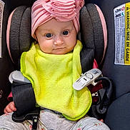 Evelynn joined the competition — help win amazing prizes! baby, infant, child, car_seat,  안전_harness, pink_hat, bib, yellow_bib, floral_pants, portrait, sitting, wide_eyes, face, indoor, vehicle, safety_buckle, harness, fashionable, cute, photography