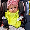baby, infant, child, car_seat,  안전_harness, pink_hat, bib, yellow_bib, floral_pants, portrait, sitting, wide_eyes, face, indoor, vehicle, safety_buckle, harness, fashionable, cute, photography