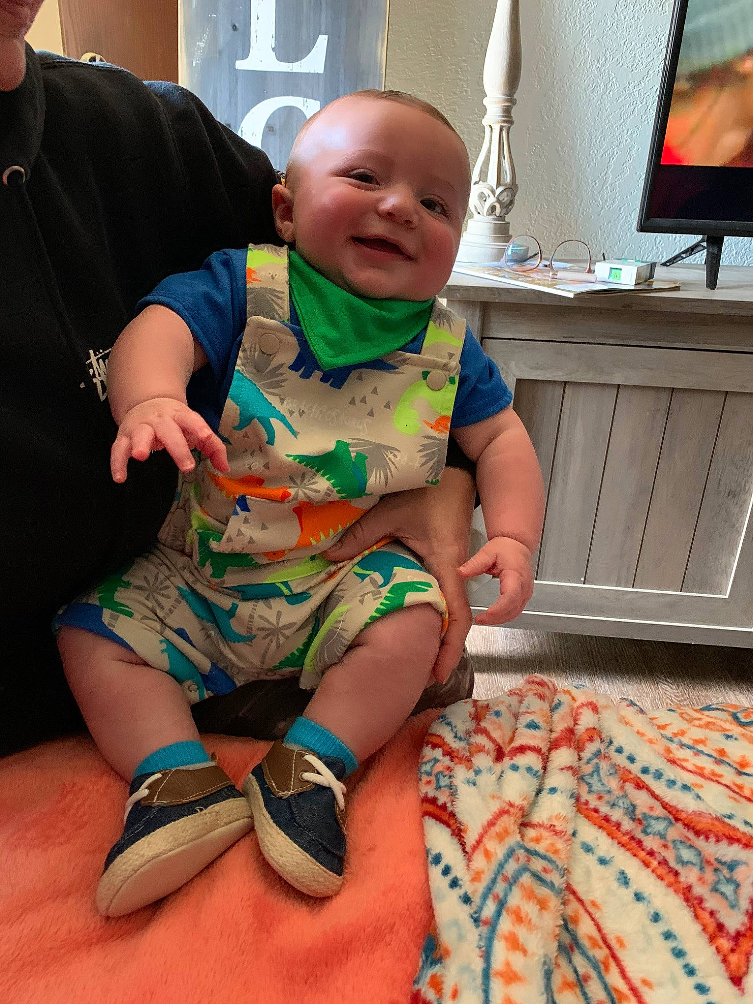 Canyon is registered to the contest to win money with this photo: arm, baby, child, finger, glasses, hand, leg, person, play, shoe, sitting, skin, t_shirt, toddler, vacation