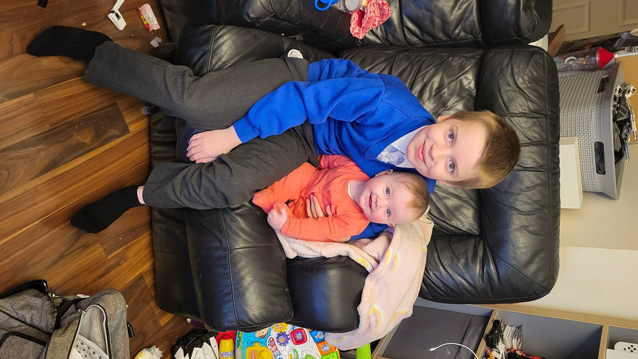 Charlotte is registered to the contest to win money with this photo: baby, bag, child, comfort, couch, event, fun, holiday, joy, lap, living_room, luggage_and_bags, person, room, sitting, suit, toddler, tree