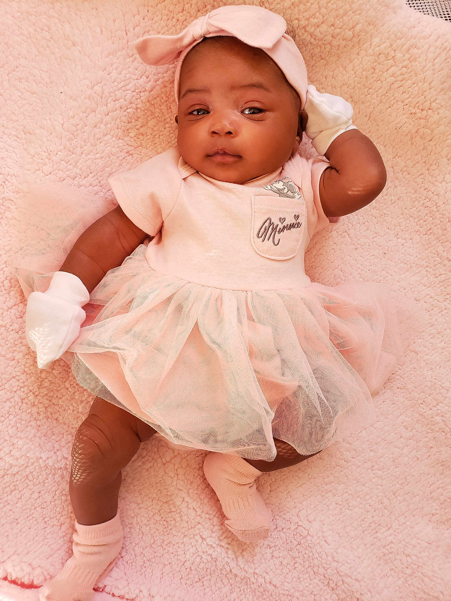 Malayna is registered to the contest to win money with this photo: baby, bodypart, bonnet, clothing, dress, face, finger, hand, happy, hardwood, hat, head, hosiery, person, photography, portrait, sitting, smile, sock, wood