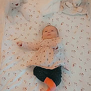 Georgina participe au concours pour gagner de l'argent avec cette photo : baby, blanket, plush_toy, stuffed_animal, giraffe_toy, bunny_toy, infant, clothing, pink_top, black_pants, orange_sock, lying_down, bed, patterned_fabric, child, cute, soft_toys, indoors, person, portrait