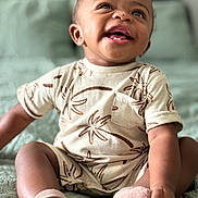 Zyaire joined the competition — help win amazing prizes! baby, infant, smiling, sitting, clothing, socks, bed, quilt, patterned_clothing, cute, happy, portrait, child, indoor, skin, face, person, young_child, tooth, expression