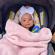 Averly joined the competition — help win amazing prizes! baby, blanket, car_seat, child, comfort, cute, face, floral, happy, headband, infant, outdoor, person, pink, portrait, seatbelt, smiling, toy, warm, white