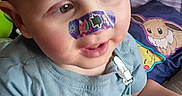 Waylon Chaos is registered to the contest to win money with this photo: arm, bandage, blue_clothing, cartoon, child, comfort, cute, expression, face, furniture, hair, hand, indoor, nose, pacifier, pillow, playful, shirt, sitting, toddler