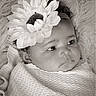Bless'In is registered to the contest to win money with this photo: baby, black_and_white, blanket, child, closeup, cuddly, curly_hair, cute, face, flower, headband, infant, newborn, peaceful, portrait, skin, sleepy, soft_texture, warm, wrapped