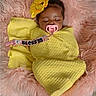 Bless'In is registered to the contest to win money with this photo: baby, blanket, child, childcare, cozy, cute, flower_headband, fluffy_rug, indoors, infant, pacifier, peaceful, person, pink, resting, sleeping, soft_texture, toddler, wrapped, yellow