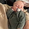 baby, pacifier, sleeping, infant, person, hand, blanket, couch, clothing, fleece, comfort, rest, cozy, indoor, soft, cute, child, holding, relaxation, home
