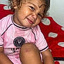 toddler, child, curly_hair, pink_shirt, soccer_jersey, miami, smiling, polka_dot_blanket, red_blanket, indoor, cute, scraped_knee, sitting, portrait, happy, young_child, casual, close_up, person, playful