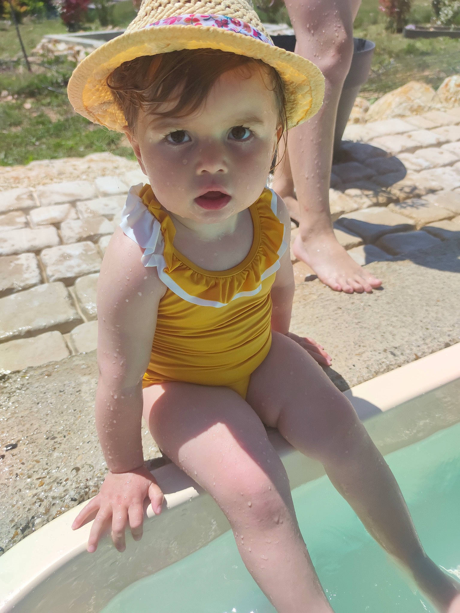 Juliette participe au concours pour gagner de l'argent avec cette photo : baby_toddler_clothing, eye, face, grass, green, hat, head, human_body, leg, mammal, person, photograph, pink, skin, sun_hat, thigh, toddler, vertebrate, water, white