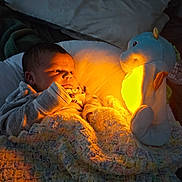 Oliver joined the competition — help win amazing prizes! baby, infant, blanket, crochet, nightlight, glow, seahorse, soft_toy, bed, pillow, warm_light, indoors, child, cute, portrait, sleepwear, rest, comfort, small, gaze