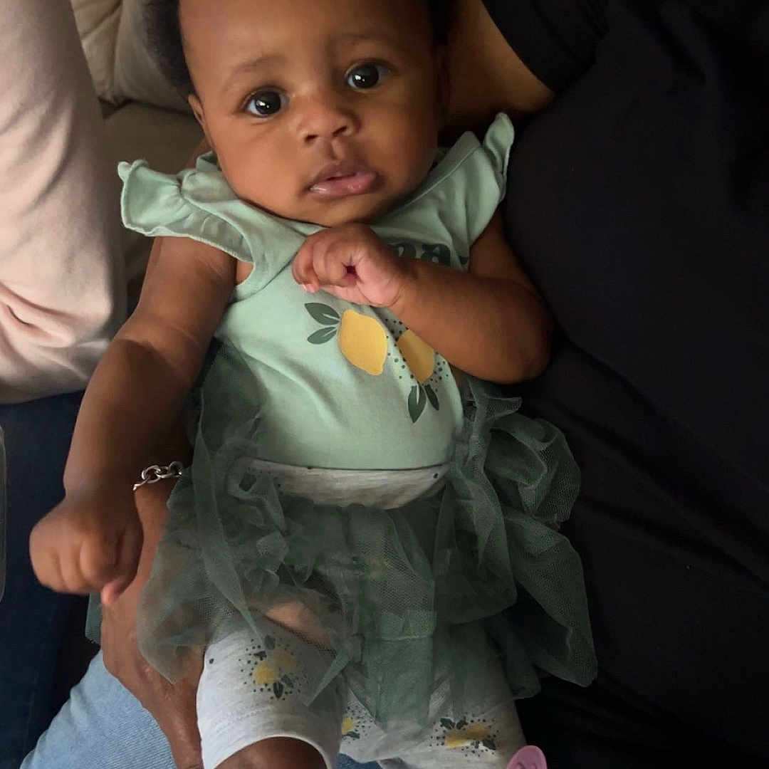 Aleiah joined the competition — help win amazing prizes! baby, bodypart, clothing, couch, cushion, dress, face, finger, furniture, hand, head, homedecor, hosiery, newborn, pants, person, photography, portrait, sitting, sock