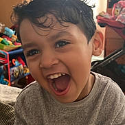 Noah Silva is registered to the contest to win money with this photo: child, childhood, closeup, cute, expression, face, fun, furniture, gray_sweater, happy, home, indoor, laughing, person, playful, portrait, smiling, toy, wet_hair, young