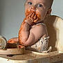 toddler, baby, high_chair, messy, food, spaghetti_sauce, eating, child, face, hand, clothing, plate, meal_time, kitchen, food_stains, mess, curious, innocent, sitting, indoor