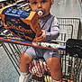Violet-Rose joined the competition — help win amazing prizes! toddler, shopping_cart, pacifier, grocery_store, snack_box, child, clothing, sneakers, aisle, shelf, shopping, supermarket, person, floor, toy, food, packaging, baby, holding, curious