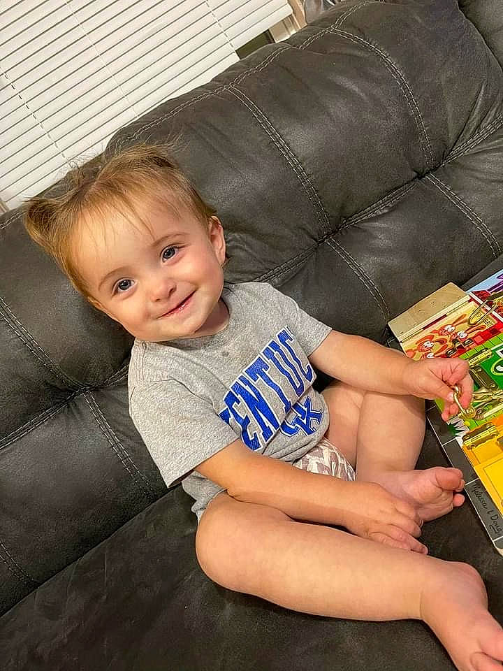 Raelynn joined the competition — help win amazing prizes! baby_toddler_clothing, barefoot, child, comfort, couch, electric_blue, flooring, foot, fun, human_leg, joy, knee, lap, living_room, person, room, shorts, sitting, smile, thigh