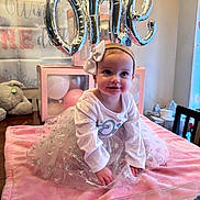 Jocelynne is registered to the contest to win money with this photo: baby, child, birthday, birthday_party, balloons, pink, tutu, dress, headband, bow, smiling, sitting, portrait, indoors, bed, blanket, stuffed_animal, cupcakes, dessert, celebration