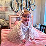 baby, child, birthday, birthday_party, balloons, pink, tutu, dress, headband, bow, smiling, sitting, portrait, indoors, bed, blanket, stuffed_animal, cupcakes, dessert, celebration