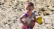 Jocelynne is registered to the contest to win money with this photo: child, toddler, beach, sand, outdoor, summer, bucket, shovel, toy, crouching, sitting, portrait, face, hair, clothing, barefoot, sunlight, shoreline, play, sandcastle