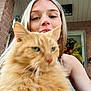 Gingy joined the competition — help win amazing prizes! woman, cat, orange_cat, fluffy_cat, pet, portrait, selfie, outdoor, porch, brick_wall, door, wreath, fall_decor, animal, feline, hair, face, smile, holding, close_up