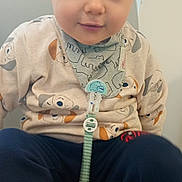 Leo participe au concours pour gagner de l'argent avec cette photo : child, toddler, baby, pacifier, bib, dog_print, shirt, pants, shoe, blue_eyes, sitting, indoor, window, seat, cute, portrait, smiling, accessory, pacifier_clip, clothing