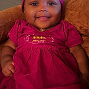 Ivory is registered to the contest to win money with this photo: baby, child, smiling, pink_dress, headband, sitting, couch, indoors, happy, cute, portrait, infant, person, clothing, fabric, skin, face, headwear, comfort, warmth
