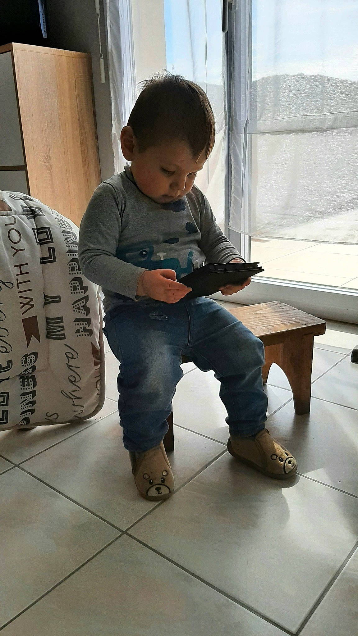 Harvey participe au concours pour gagner de l'argent avec cette photo : baby_toddler_clothing, child, floor, flooring, foot, fun, hardwood, joint, knee, leg, person, shoe, sitting, sleeve, sneakers, sock, t_shirt, thigh, toddler, window