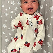 Kota joined the competition — help win amazing prizes! baby, infant, onesie, american_flag, stars_pattern, blanket, smiling, happy, lying_down, cute, child, face, head, clothing, fabric, pattern, indoors, young_child, person, apparel