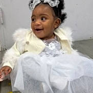 Jaliyah joined the competition — help win amazing prizes! child, girl, baby, dress, white_dress, jacket, lace_bows, curly_hair, smiling, sitting, floor, wooden_floor, indoors, happy, cute, portrait, person, fashion, toddler, young_child