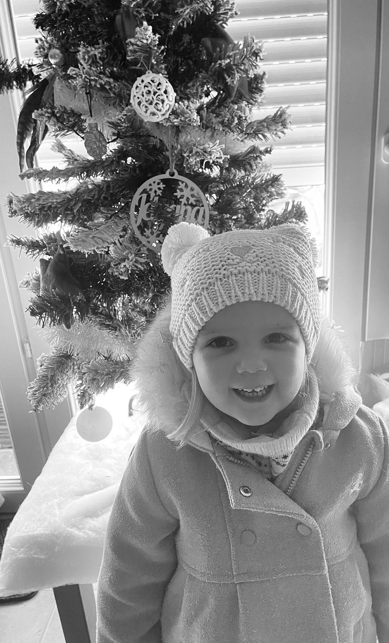 Aimy-rose participe au concours pour gagner de l'argent avec cette photo : baby_toddler_clothing, black, black_and_white, cap, christmas_ornament, christmas_tree, evergreen, happy, headgear, headwear, holiday_ornament, monochrome, monochrome_photography, ornament, person, photograph, sleeve, smile, standing, style